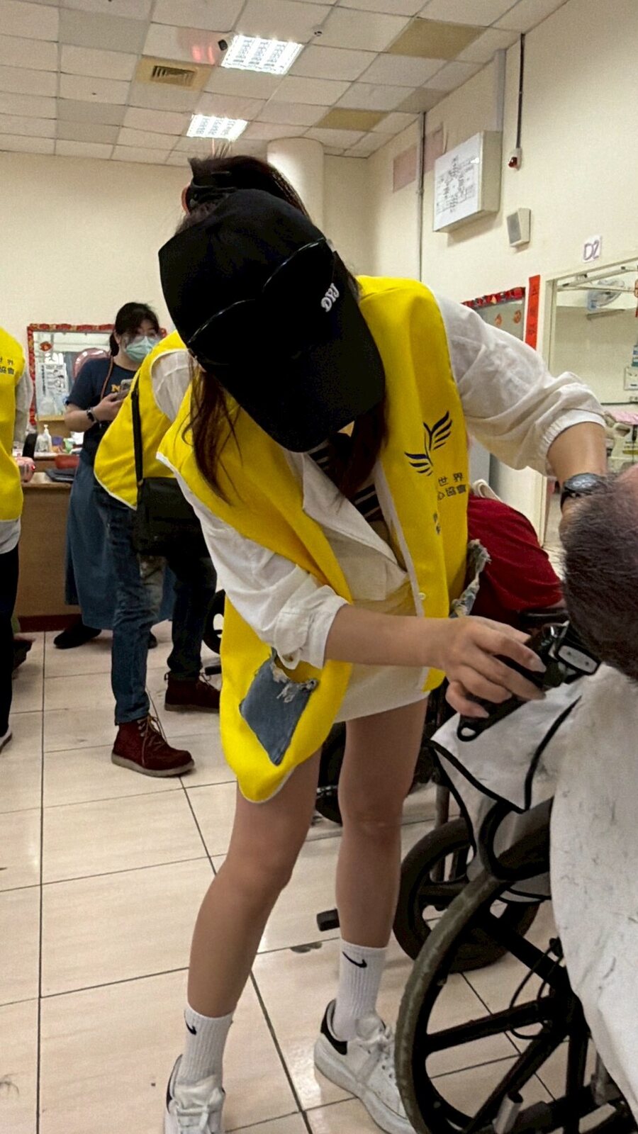 志工蹲下來，陪伴行動不便的長輩